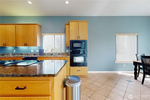 a kitchen with granite countertop a stove a sink and a microwave