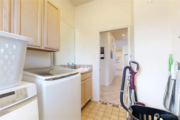 a bathroom with a granite countertop sink and a washing machine