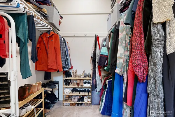 a view of walk in closet with clothes and shoes