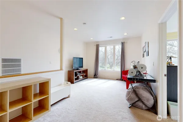 a living room with furniture gym equipment and a large window