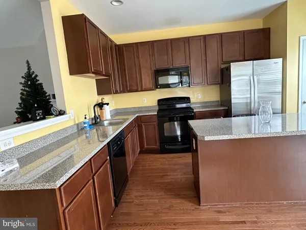 a kitchen with kitchen island granite countertop a sink a counter top space and cabinets