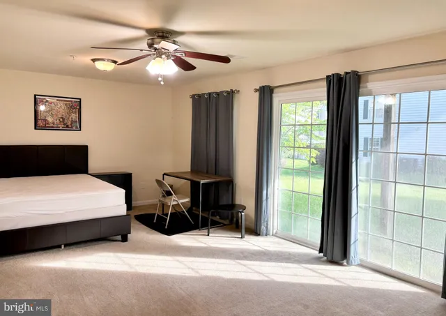 a bedroom with a bed and a large window