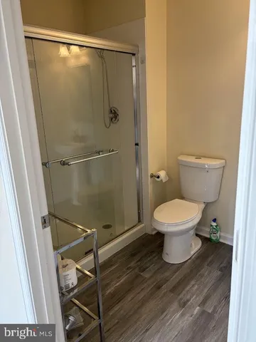 a white toilet sitting next to a shower