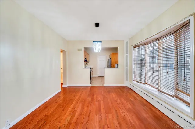 a view of a room with wooden floor and a window