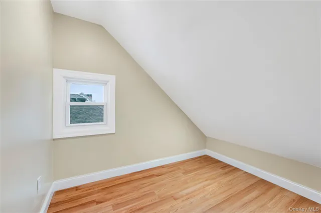 a walk in closet with wooden floor