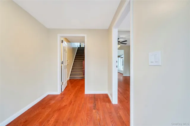 a view of a hallway with wooden floor and staircase
