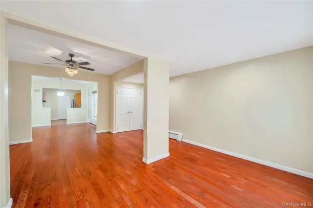 an empty room with wooden floor and mirror
