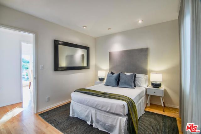 a bedroom with a bed and a painting on the wall