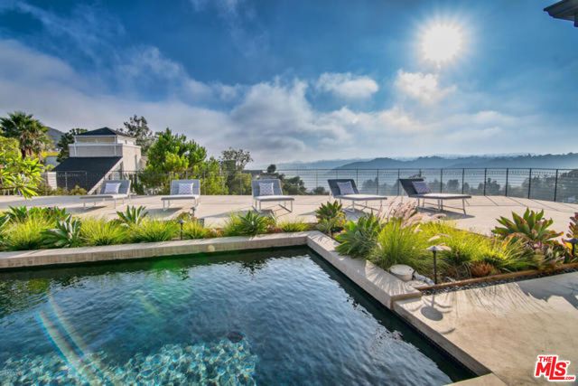 a view of swimming pool with a garden and seating area