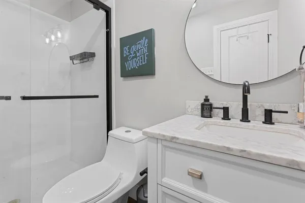 a bathroom with a sink a toilet and a mirror