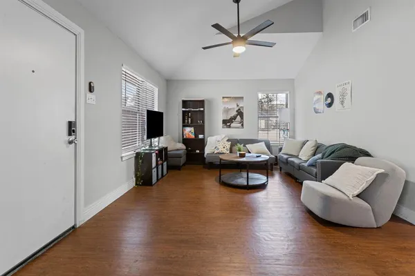 a living room with furniture and a wooden floor