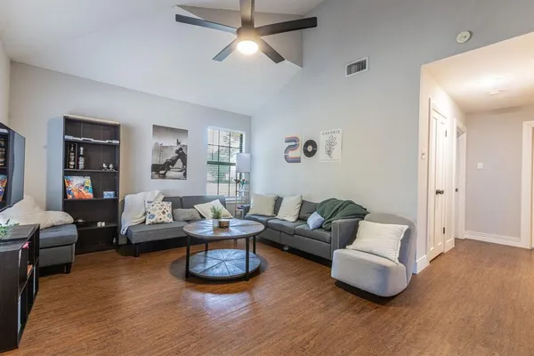 a living room with furniture and a wooden floor