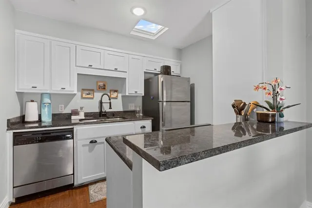 a kitchen with stainless steel appliances granite countertop a sink a refrigerator and a granite counter tops