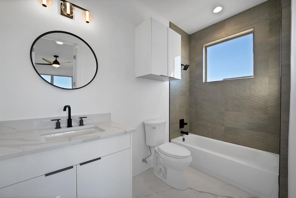 443 Whispering Way Red Oak, TX 75154 - Photo 29 of 36 a bathroom with a toilet a sink a mirror and bathtub