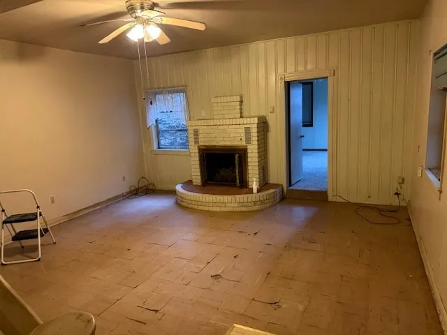 a view of a livingroom with a fireplace and a ceiling fan