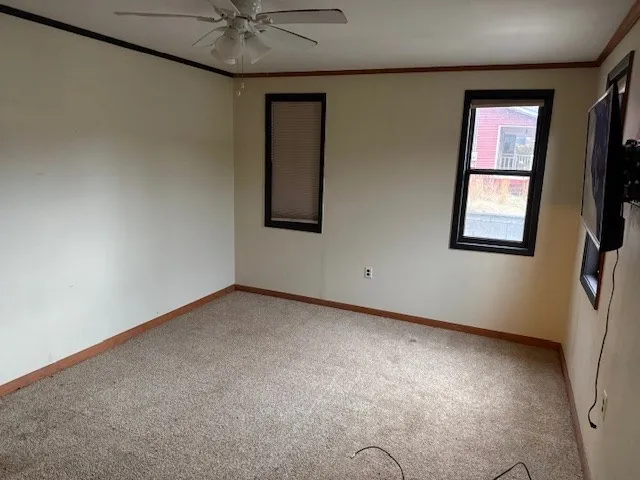 an empty room with windows and fan