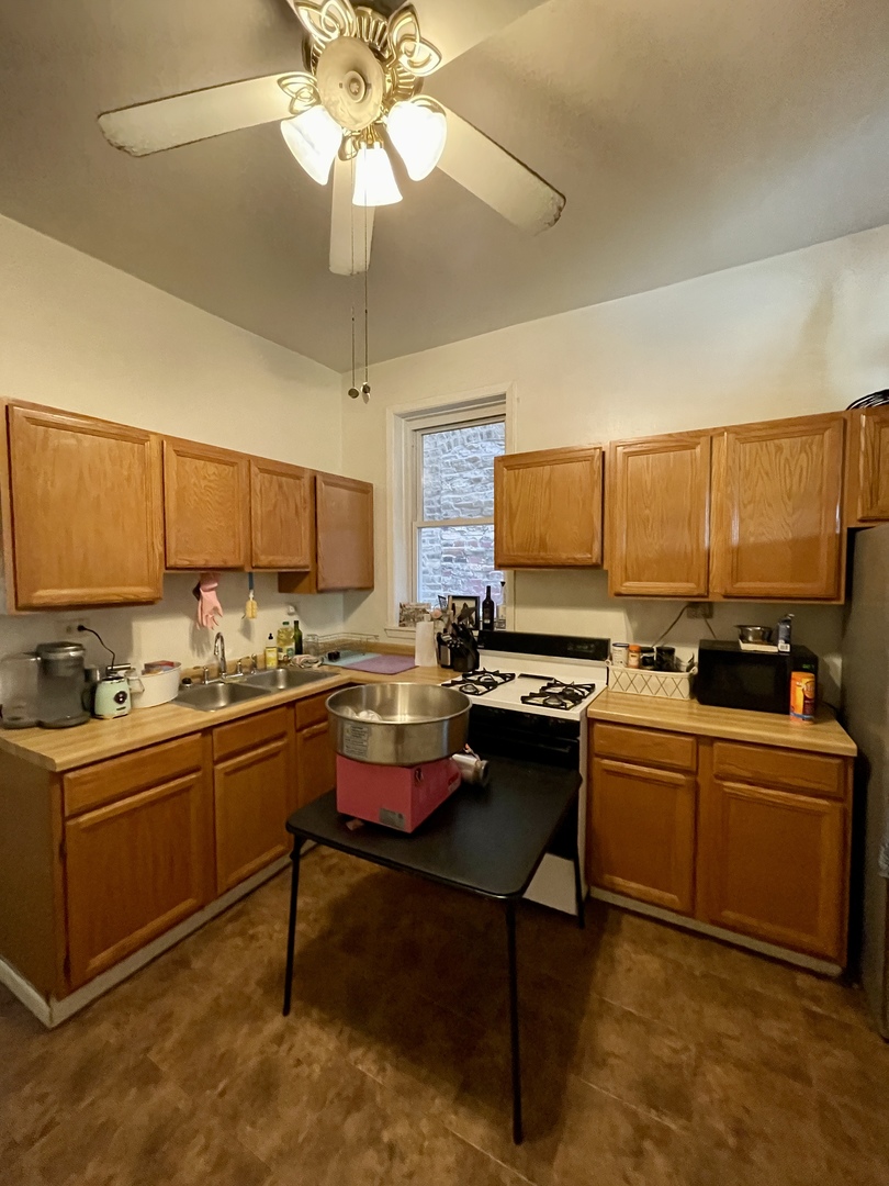 1907 West Cortland Street, Unit 2 Chicago, IL 60622 - Photo 6 of 11 a kitchen with stainless steel appliances kitchen island granite countertop a sink and cabinets