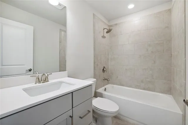 a bathroom with a sink toilet vanity and bathtub