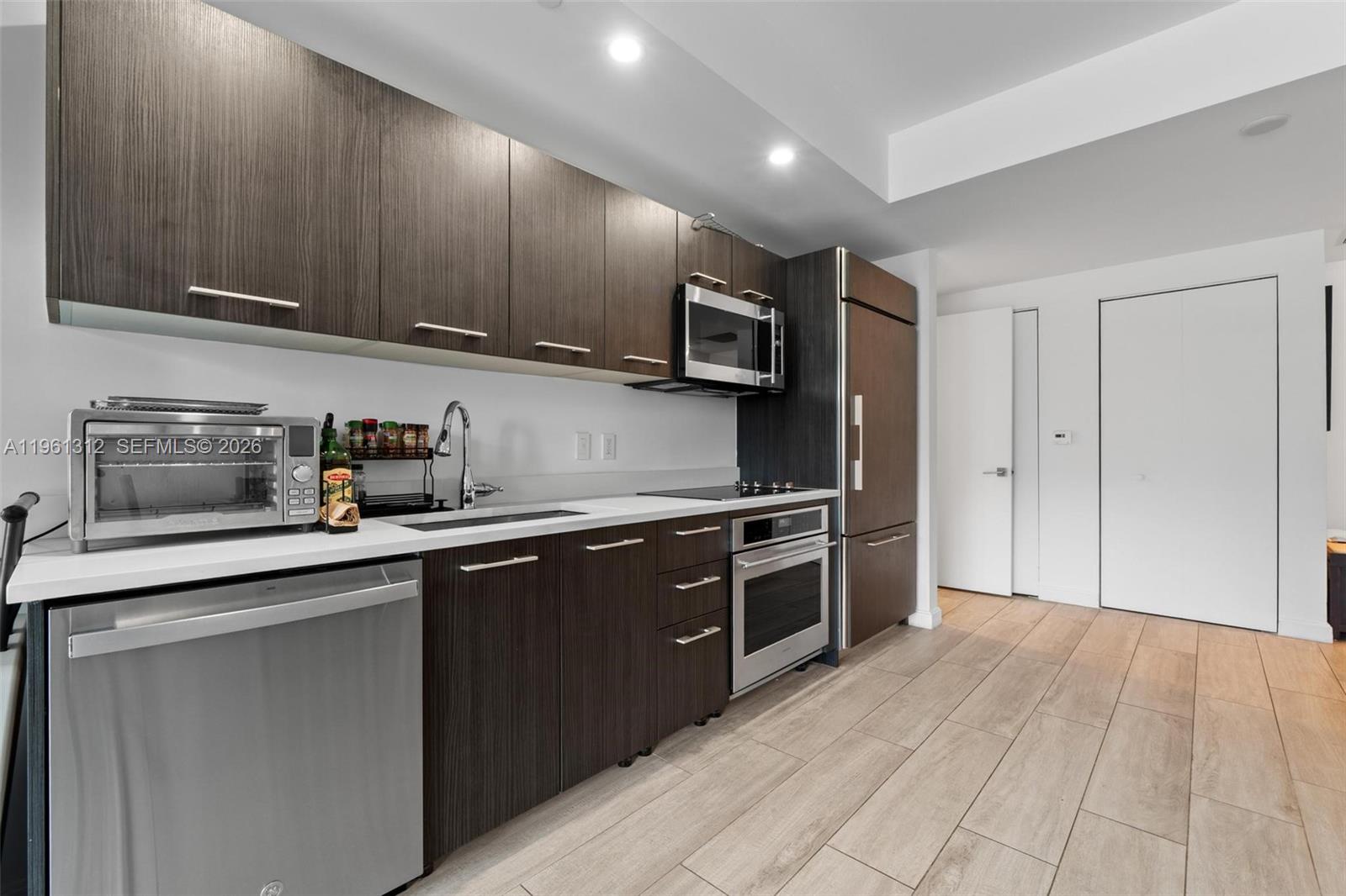 45 Southwest 9th Street, Unit 1109 Miami, FL 33130 - Photo 4 of 25 a kitchen with stainless steel appliances granite countertop a sink and cabinets
