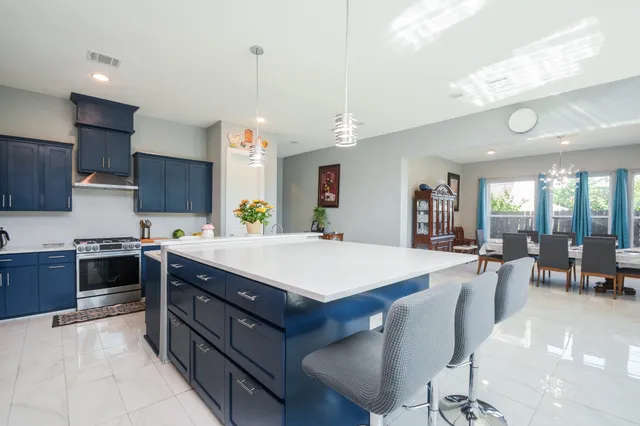 a large kitchen with stainless steel appliances and a dining table