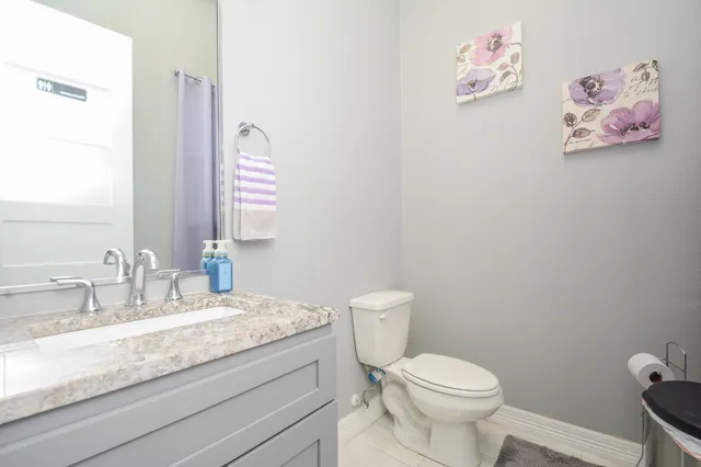 a bathroom with a granite countertop sink mirror vanity and toilet