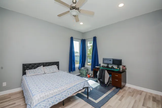 a bedroom with a bed a large window and flat screen tv