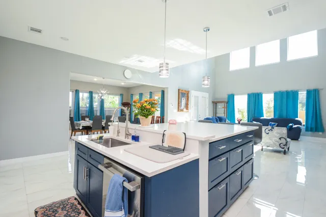 a room with a sink dishwasher and a large mirror with wooden floor