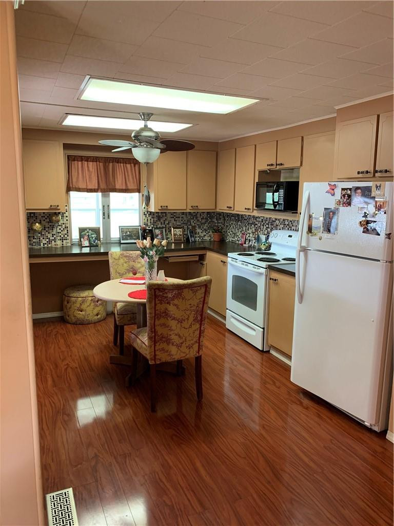 8257 East Club Road Boca Raton, FL 33433 - Photo 13 of 28 a kitchen with a sink dishwasher a stove and white cabinets with wooden floor