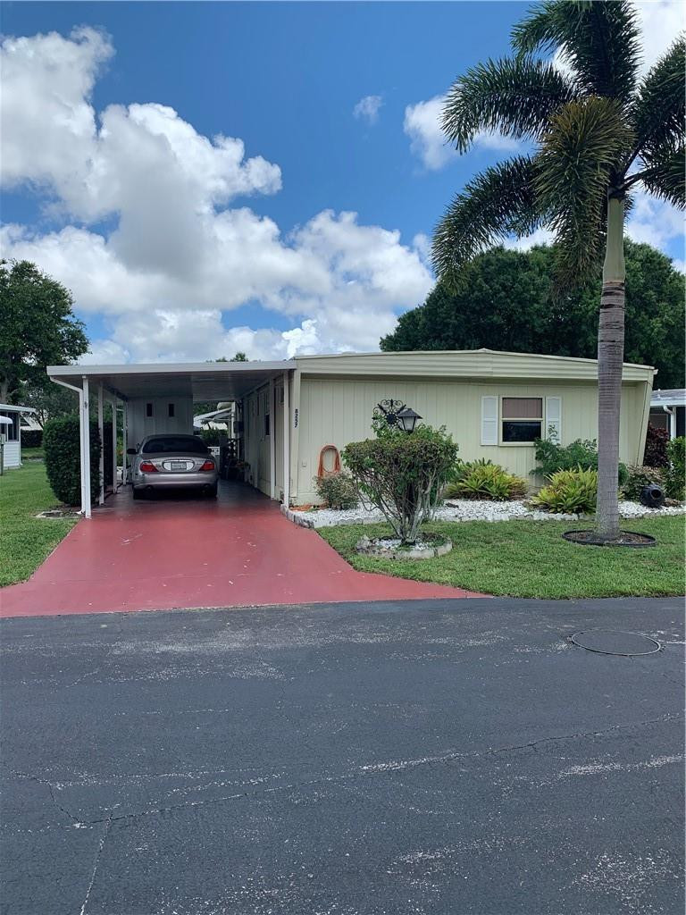 8257 East Club Road Boca Raton, FL 33433 - Photo 3 of 28 a yellow and red house with a yard