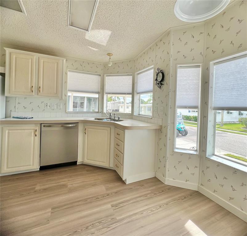 1100 South Belcher Road, Unit 391 Largo, FL 33771 - Photo 13 of 60 a kitchen with a white cabinets and wooden floor