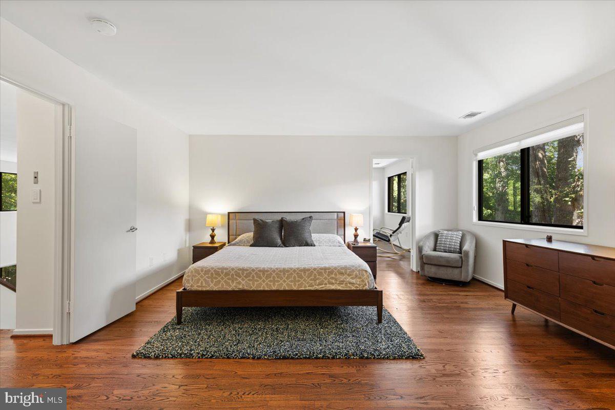 9411 Fernwood Road Bethesda, MD 20817 - Photo 14 of 28 a bedroom with a large bed a couch and large window