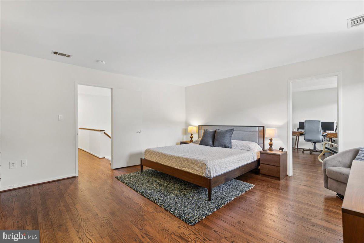 9411 Fernwood Road Bethesda, MD 20817 - Photo 16 of 28 a bedroom with a bed and wooden floor