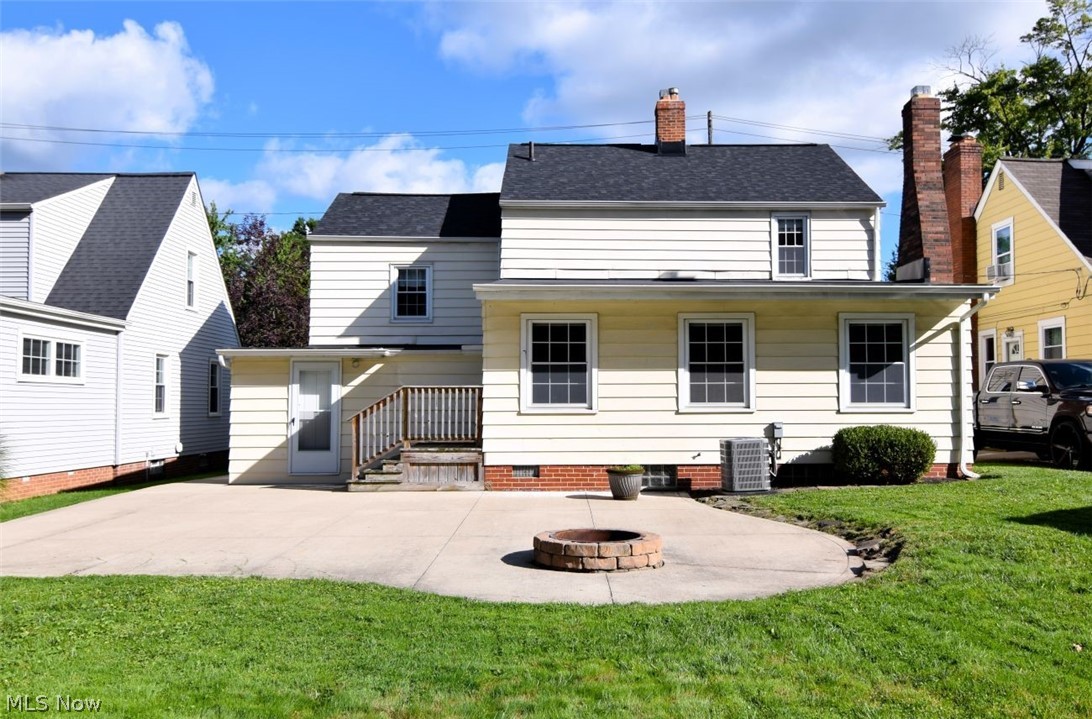 5284 Edenhurst Road Lyndhurst, OH 44124 - Photo 50 of 50 Expansive concrete patio with a built-in fire pit, surrounded by a manicured lawn