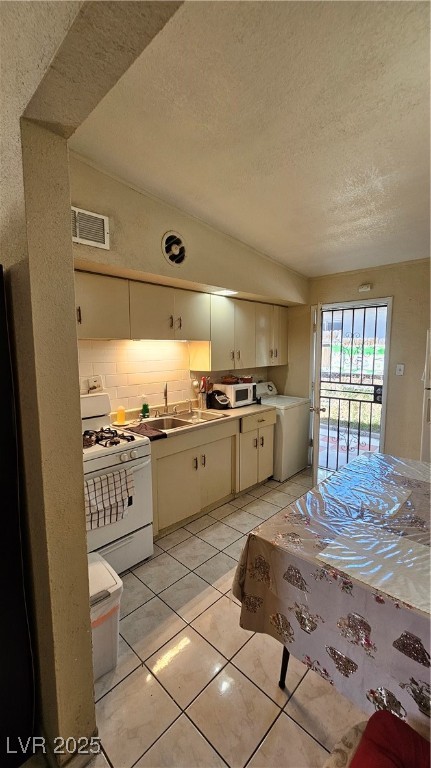 2120 Glider Street North Las Vegas, NV 89030 - Photo 21 of 50 Kitchen with lofted ceiling, stove, washer / dryer