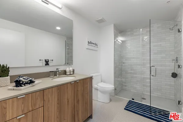 a bathroom with a granite countertop sink a toilet and shower