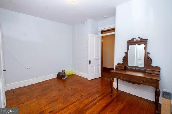 a kitchen with stainless steel appliances granite countertop a refrigerator a sink dishwasher a stove and white cabinets with wooden floor