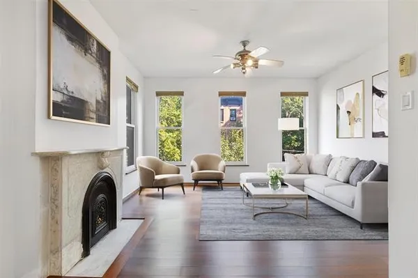 a living room with furniture a fireplace and a large window