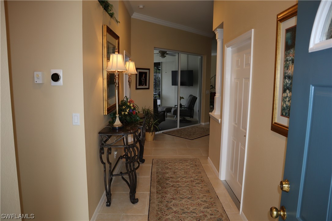 10325 Cape Roman Road, Unit 101 Estero, FL 34135 - Photo 3 of 34 a view of a hallway with wooden floor and a dining room