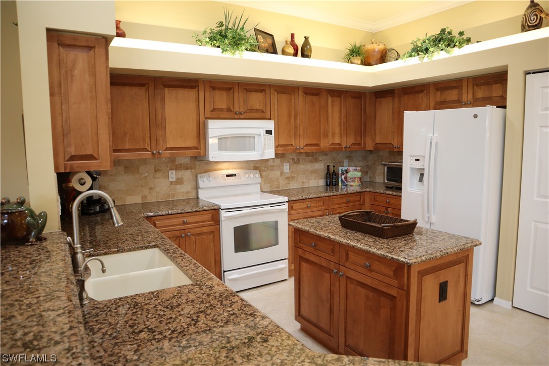 10325 Cape Roman Road, Unit 101 Estero, FL 34135 - Photo 5 of 34 a kitchen with a stove and a refrigerator