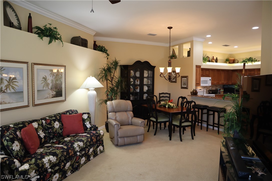 10325 Cape Roman Road, Unit 101 Estero, FL 34135 - Photo 9 of 34 a living room with furniture kitchen view and a chandelier