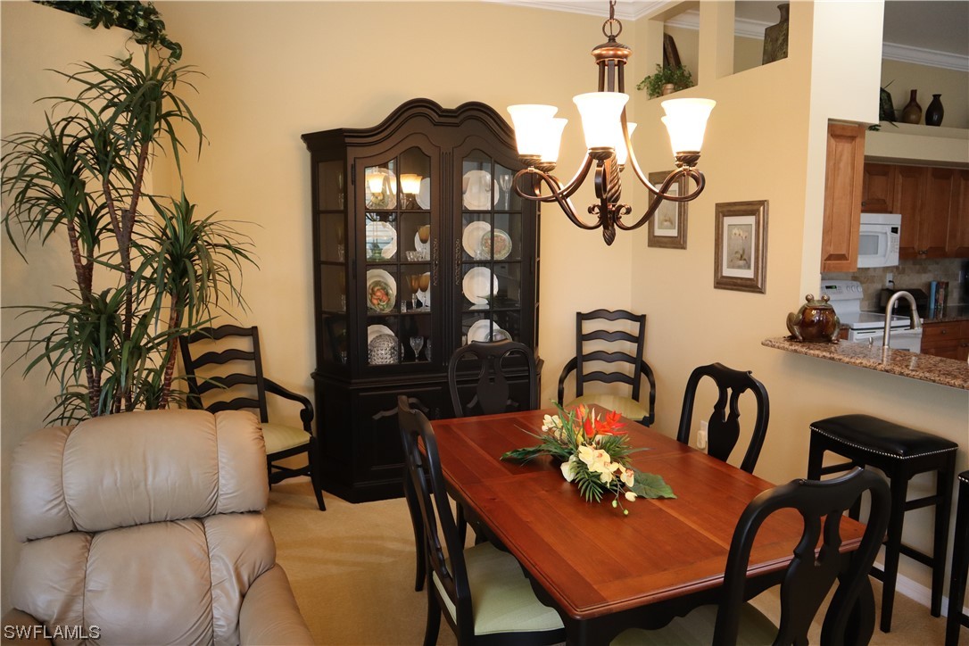 10325 Cape Roman Road, Unit 101 Estero, FL 34135 - Photo 10 of 34 a view of a dining room with furniture and chandelier