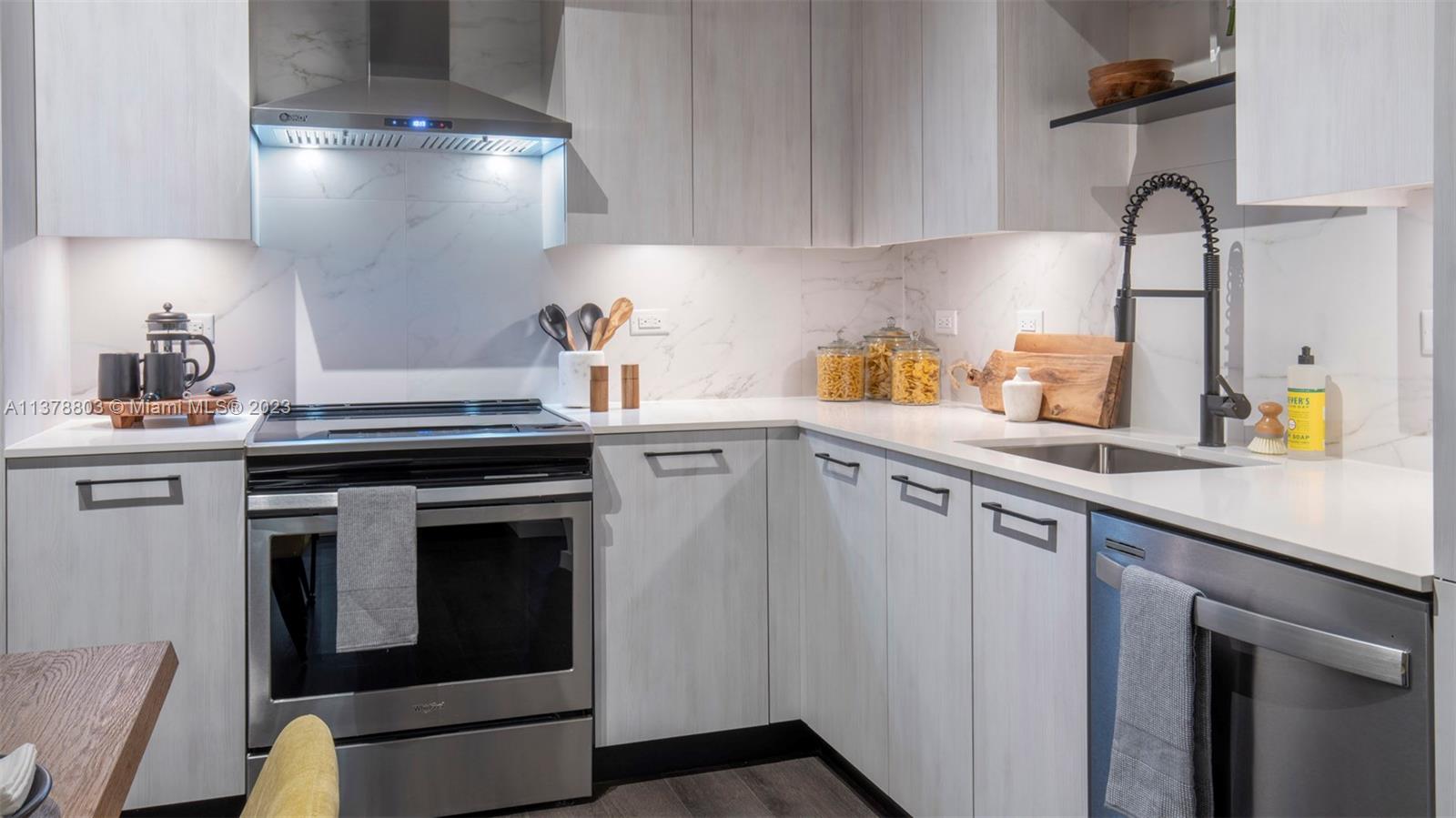 6970 Southwest 40th Street, Unit 442 Miami, FL 33155 - Photo 6 of 23 a kitchen with stainless steel appliances granite countertop a sink stove and cabinets
