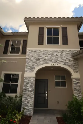 a front view of a house with plants