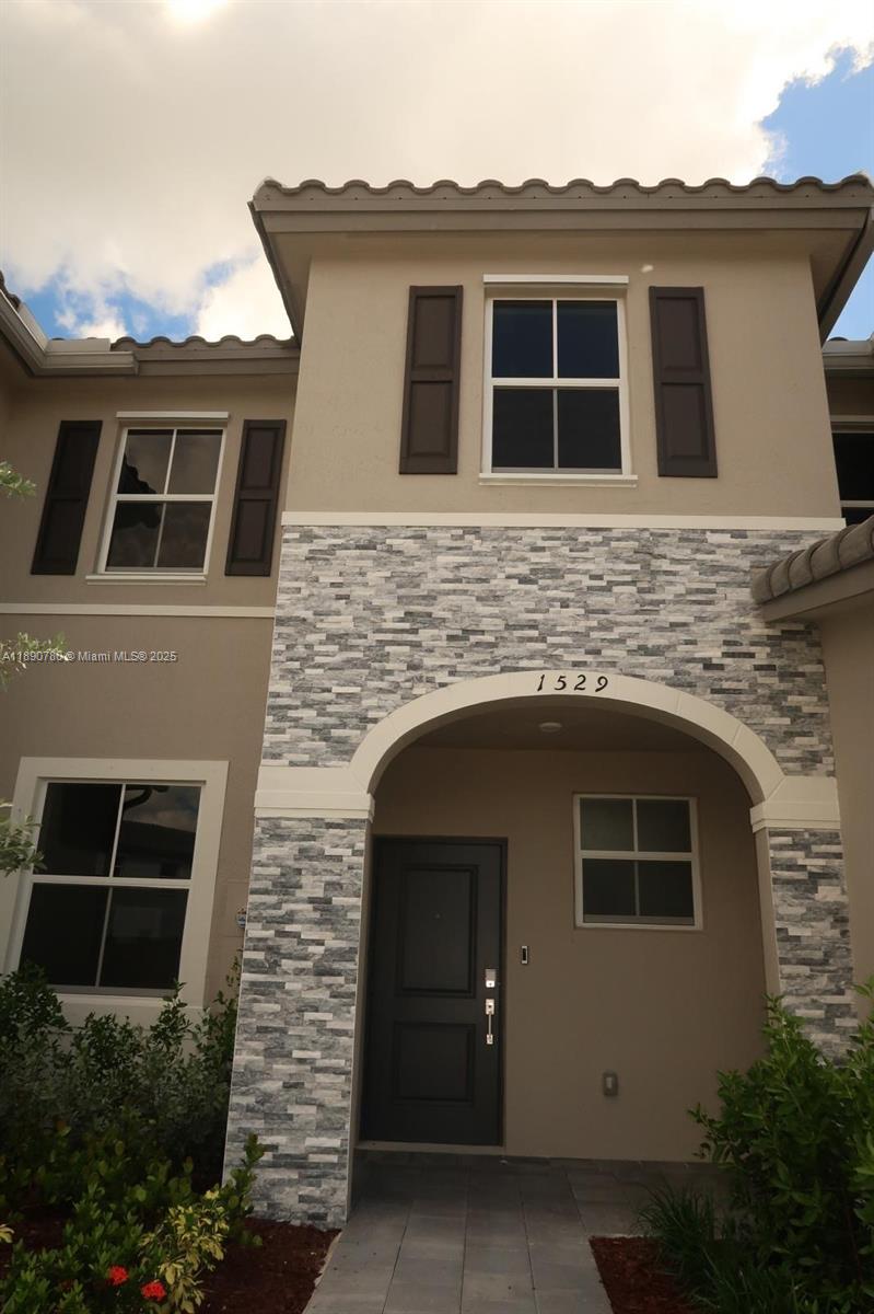 a front view of a house with plants