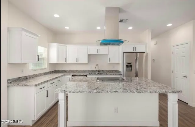 a kitchen with stainless steel appliances granite countertop a sink a stove and a refrigerator