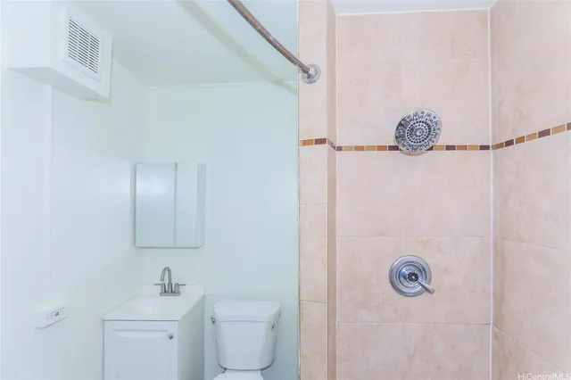 a bathroom with a granite countertop sink a toilet and shower