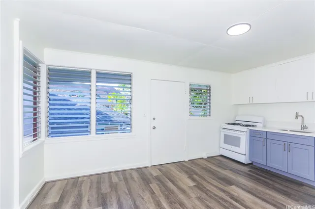 a view of a kitchen with a sink wooden cabinets and entryway
