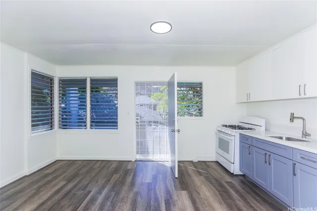 a kitchen with wooden floors and white cabinets