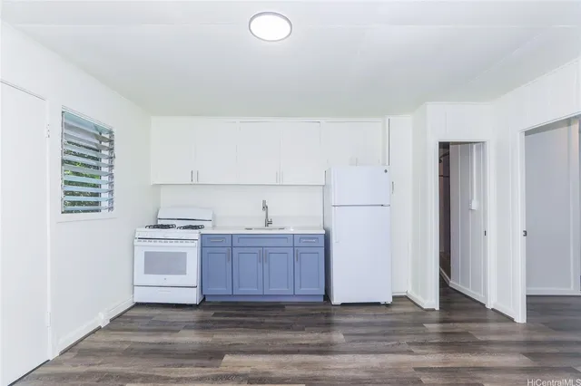 a kitchen with cabinets wooden floor and stainless steel appliances