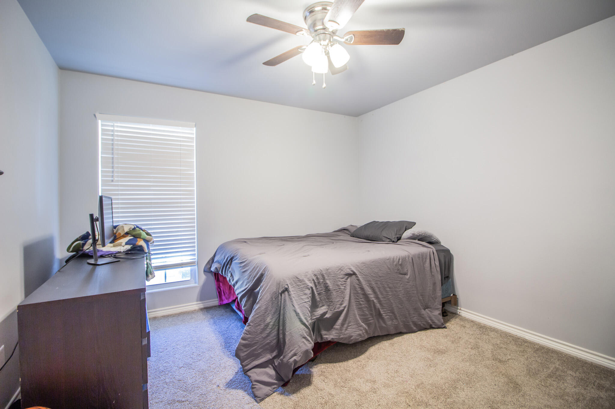 8808 14th Street Lubbock, TX 79416 - Photo 13 of 19 a bedroom with a bed and a chandelier